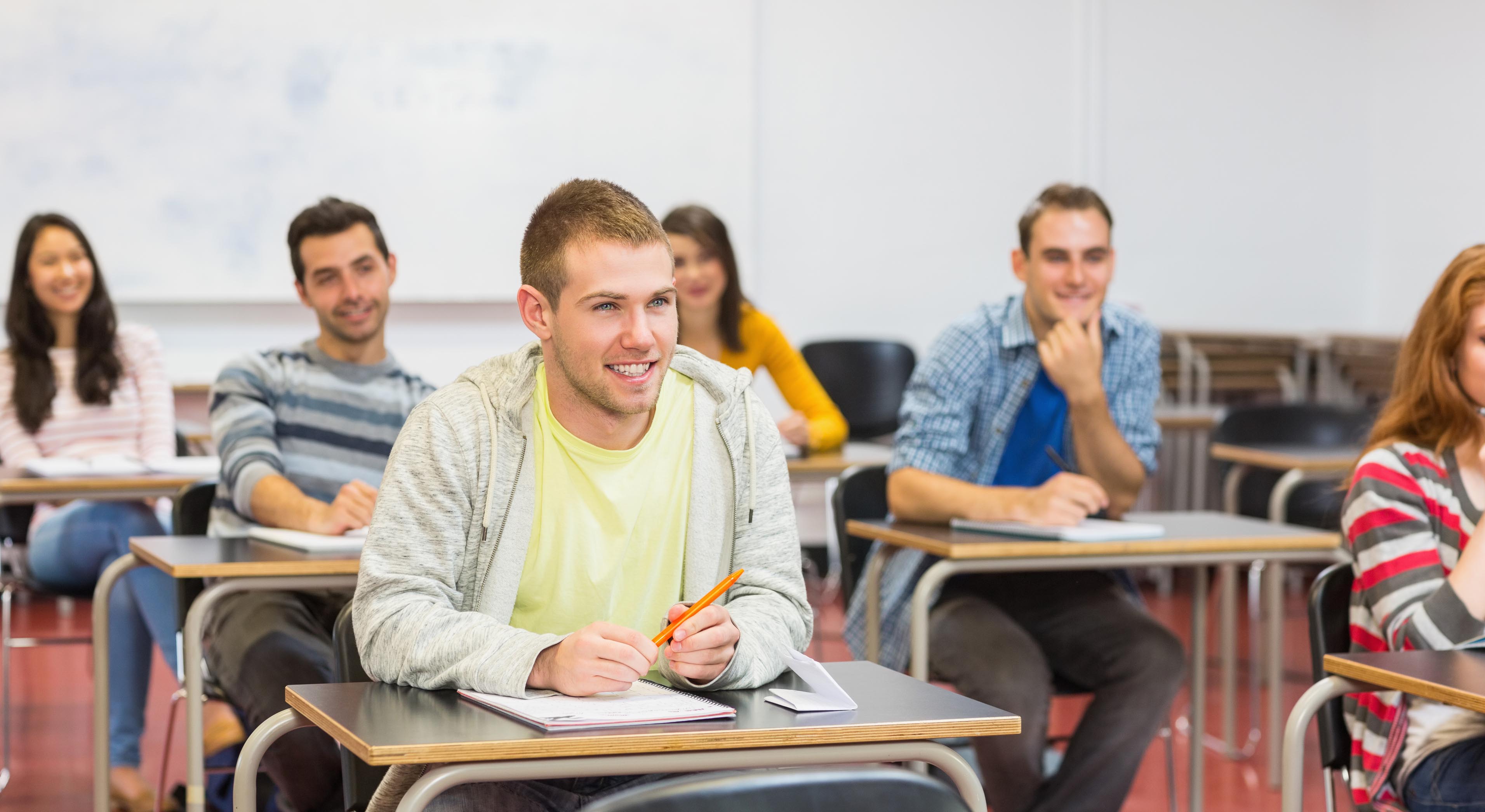Group of young students smiling in the college classroom