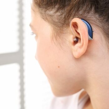 young-woman-showing-off-her-new-blue-hearing-aids
