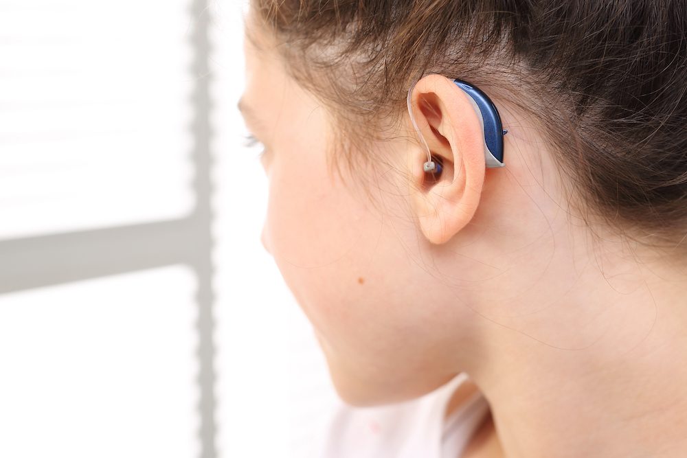 young-woman-showing-off-her-new-blue-hearing-aids